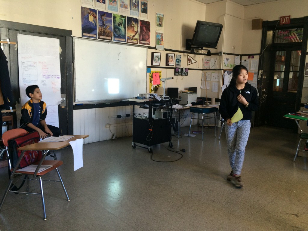 A student reading her original poetry during a class poetry slam.